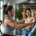 Diverse vrouwen trainen op hydraulische apparatuur in een zonnige Curves-fitnessruimte, begeleid door een vriendelijke coach tijdens het 30-minuten circuit.