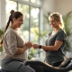 Twee vrouwen met diverse lichaamstypen trainen in een rustige Curves-studio met hydraulische apparatuur in circuitopstelling, begeleid door een coach.