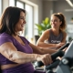 Vrouwen trainen op hydraulische apparatuur in een lichte Curves fitnessstudio, begeleid door een coach in een veilige, vrouwelijke omgeving.