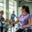 Diverse vrouwen trainen op hydraulische weerstandsmachines in een lichte, moderne fitnessstudio terwijl een coach begeleiding biedt in een uitnodigende, groene omgeving.