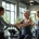 Diverse vrouwen trainen in een lichte, moderne Curves sportschool terwijl een vriendelijke coach begeleiding biedt in een ondersteunende, vrouwengerichte fitnessomgeving.