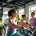 Diverse vrouwen trainen op hydraulische apparatuur in lichte, moderne fitnessruimte voor vrouwen. Coach biedt begeleiding bij 30-minuten circuittraining in ontspannen sfeer.