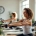 Vrouwen trainen op hydraulische machines in een lichte fitnessstudio voor vrouwen, met coach begeleiding tijdens een 30-minuten circuit.