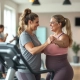 Vrouwen trainen samen op hydraulische apparatuur in een cirkelvormige Curves-fitnessruimte, begeleid door een coach in een warme, uitnodigende omgeving met paarse accenten.
