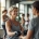 50+ vrouw traint met lichte gewichten in moderne fitnessruimte terwijl een coach haar begeleidt. Diverse vrouwen oefenen op hydraulische apparatuur in een warme, uitnodigende sfeer.