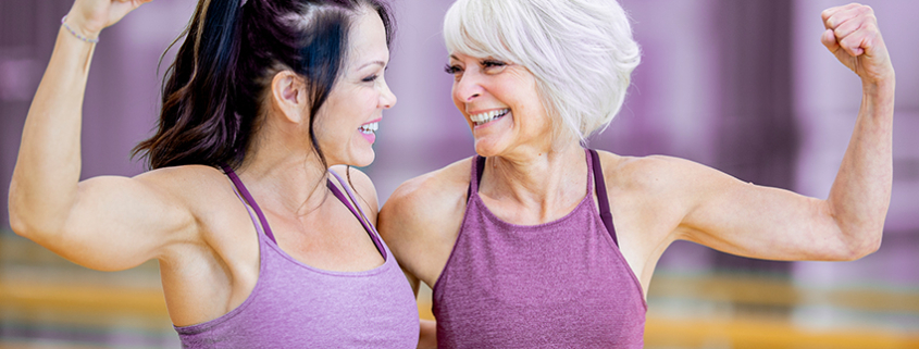 Vrouwen van boven de 50 trainen op hydraulische krachtapparatuur in cirkelopstelling bij Curves, begeleid door coach in ondersteunende en lichte fitnesszaal.