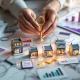 Zakenvrouw houdt gouden sleutel boven miniatuur franchise winkels met financiële documenten op marmeren oppervlak