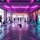 Vrouwen trainen in moderne fitnessstudio met paarse en turquoise verlichting en hydraulische fitnessapparatuur