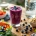Houten tafel met post-workout voeding: proteïne smoothie, zalm, quinoa salade, Griekse yoghurt en water fles
