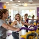 Vrouwen van 30-40 jaar trainen samen op paarse en gele fitnessapparatuur in uitnodigende Curves sportschool