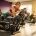 Vrouw van middelbare leeftijd stelt gewichtsplaten in op hydraulische weerstandsmachine in helder verlichte fitnessstudio