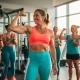 Zelfverzekerde vrouw in de veertig toont trots haar biceps in moderne sportschool met diverse groep vrouwen