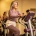 Vrouw van middelbare leeftijd stapt vastberaden op een Curves hydraulisch fitnessmachine in een warm verlichte sportschool.